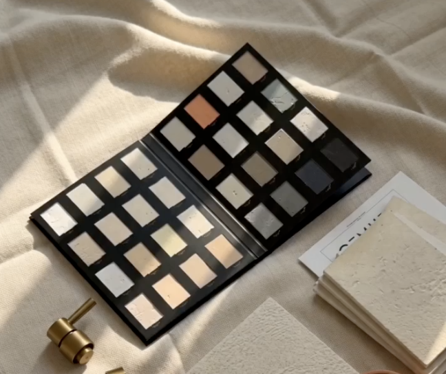 Microcem applicator presenting hand-trowelled microcement colour samples to a client